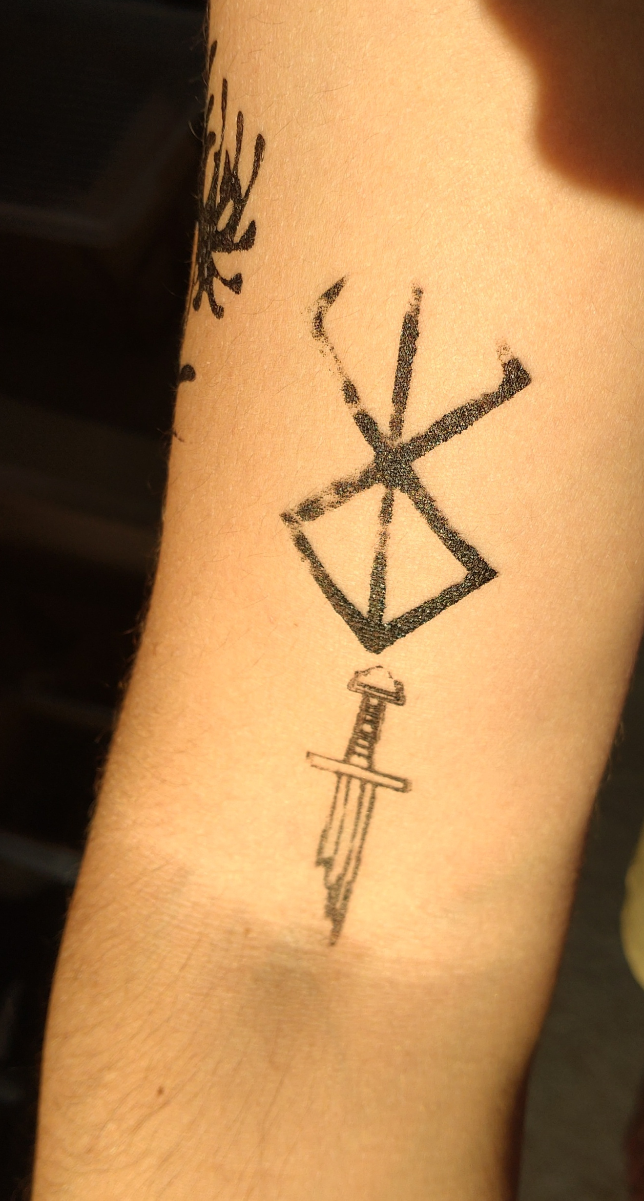 Tatouage emblème Berserk traits droit